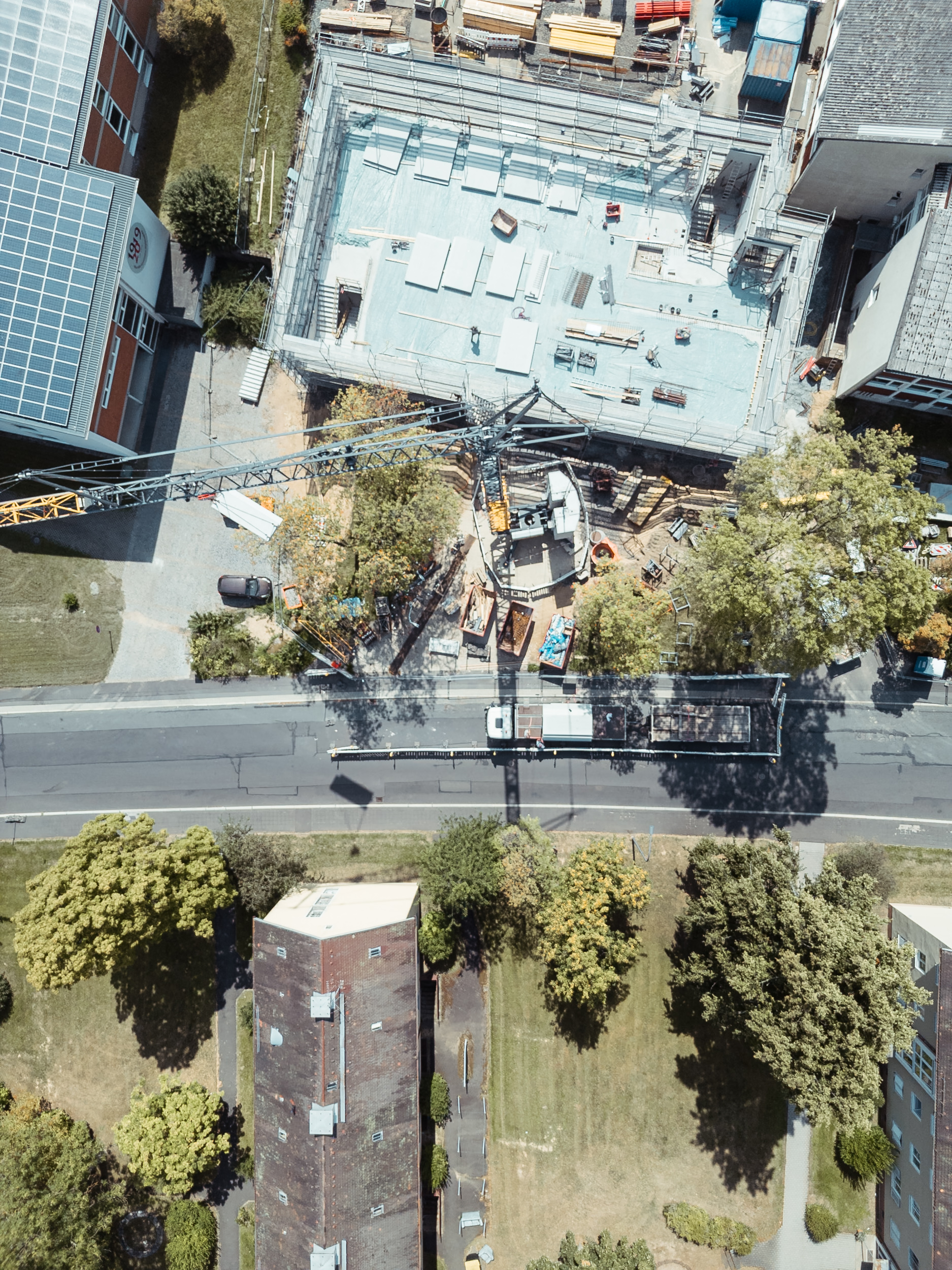 Luftaufnahme einer Baustelle mit Kran und Betonfertigteilen